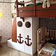 Loft bed in a marine style with decorative elements in the form of an anchor, helm, rope. It will be appreciated by little adventurers.
