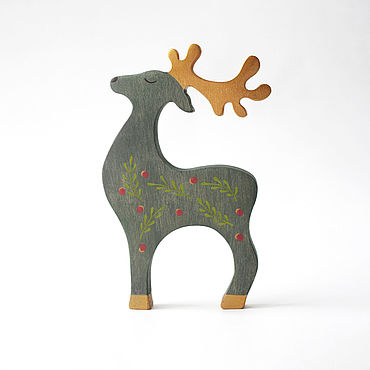 руки держат деревянную фигурку оленя